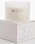 MR AND MRS CANDLE WITH LOVE SITTING ON TOP OF THE BOX IT COMES IN, THE BOX IS WHITE WITH SILVER AND BLACK DECALS
