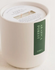 WHITE CANDLE WITH A GREEN LABEL THAT SAYS ARABICA FOREST BY TERRA, SHOWN STANDING UP