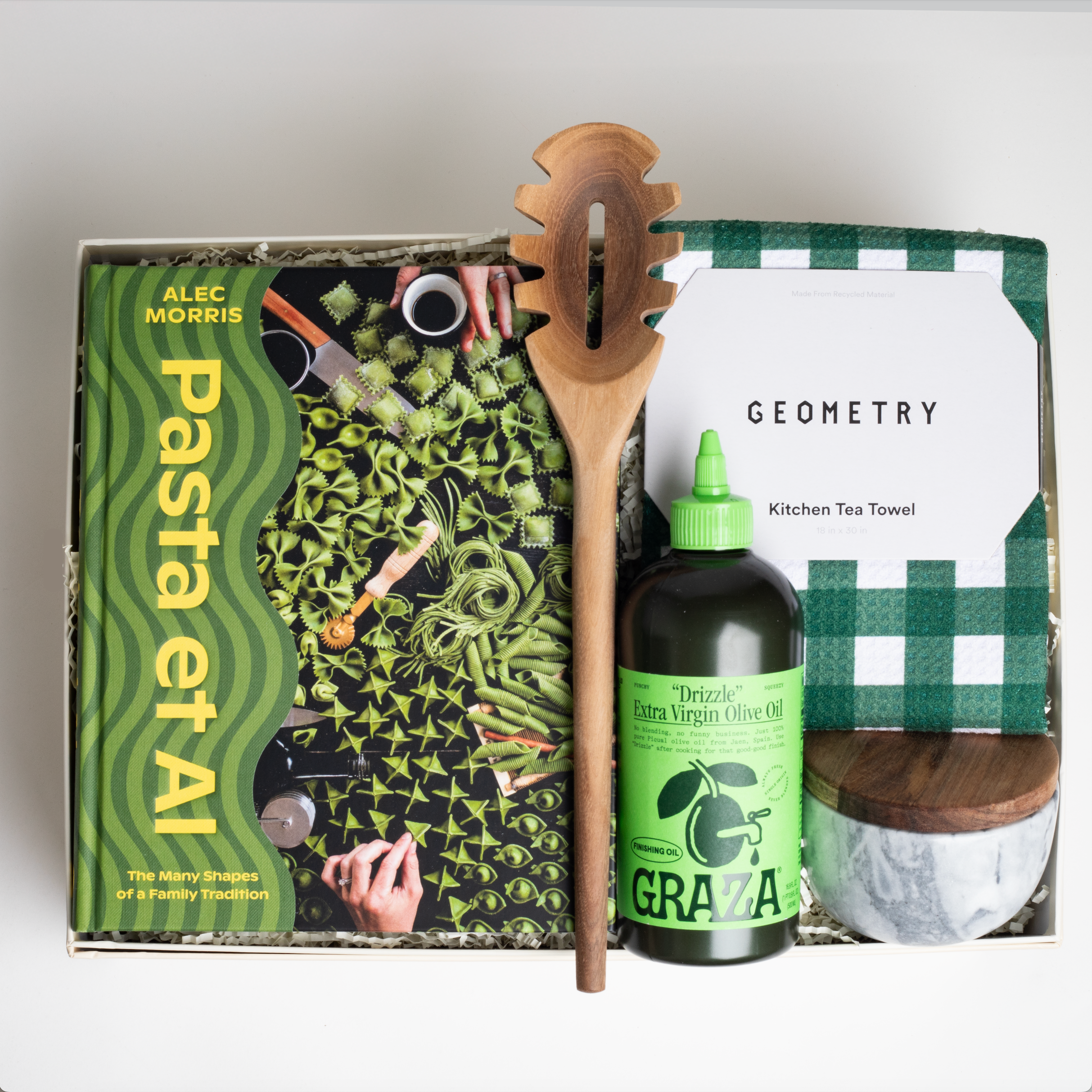 PASTA ET AL gift box which includes: Pasta Et Al cookbook, Wooden Pasta Spoon, Graza "Drizzle" Olive Oil, Geometry Green Checkered Tea Towel, and Marble Salt Cellar with wooden top