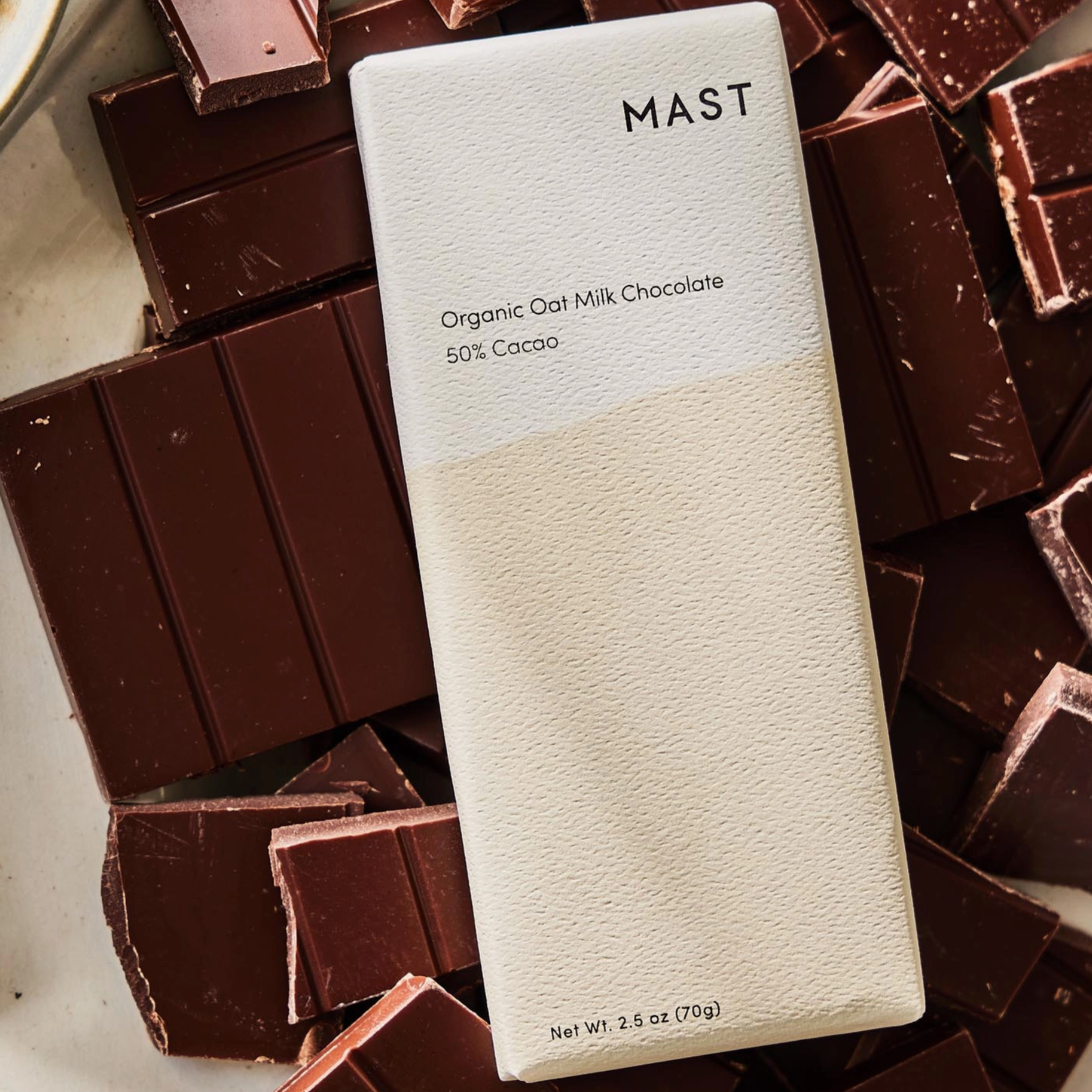 Cream and white chocolate bar package laying on top of chocolate bars