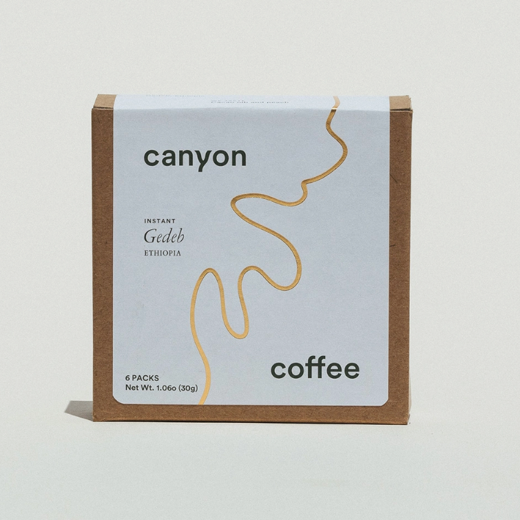 A box of Canyon Coffee instant coffee with a minimalist design, featuring a beige and white color scheme and the brand's logo.