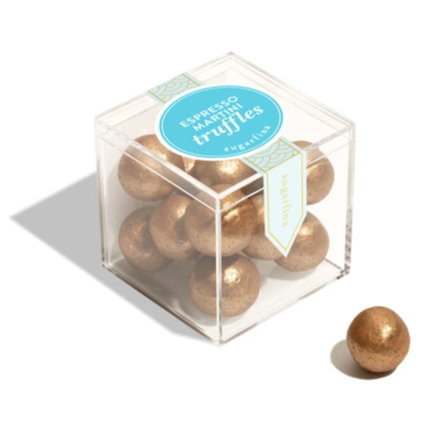 Clear cube box with gold truffles and a blue label on a white background