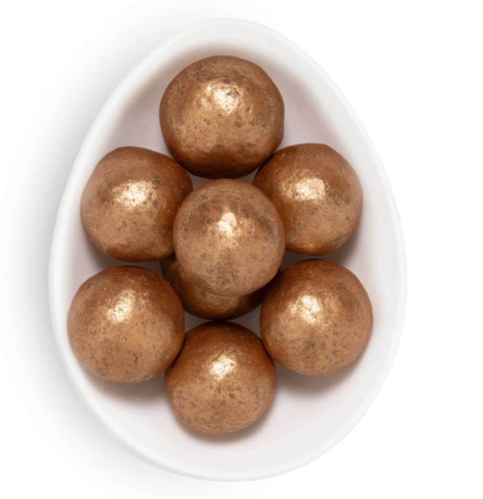 Brown spherical objects in a white bowl on a white background