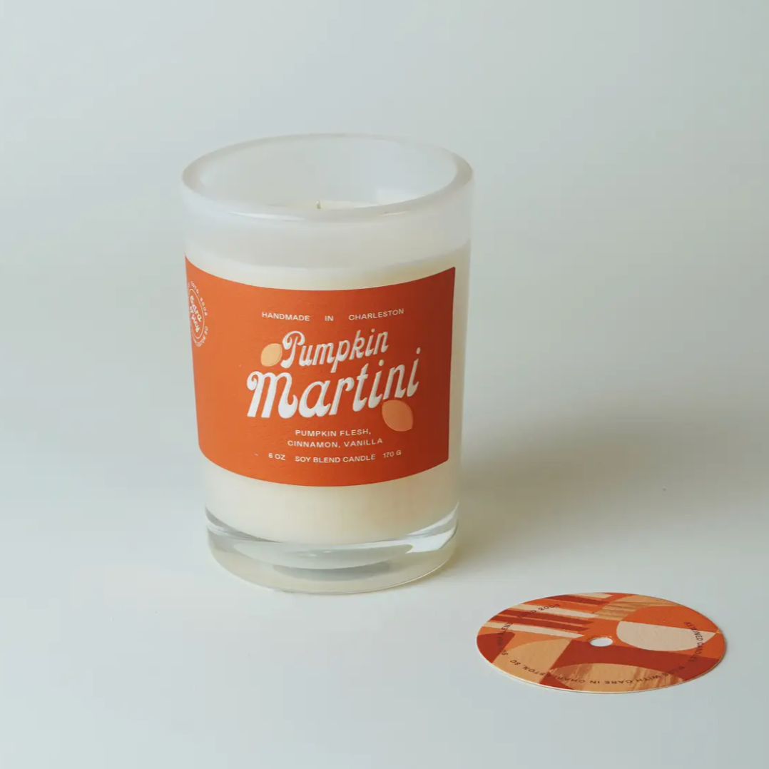 Candle in a glass jar with a 'Pumpkin Martini' label on a white background