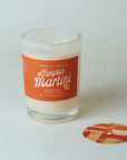 Candle in a glass jar with a 'Pumpkin Martini' label on a white background