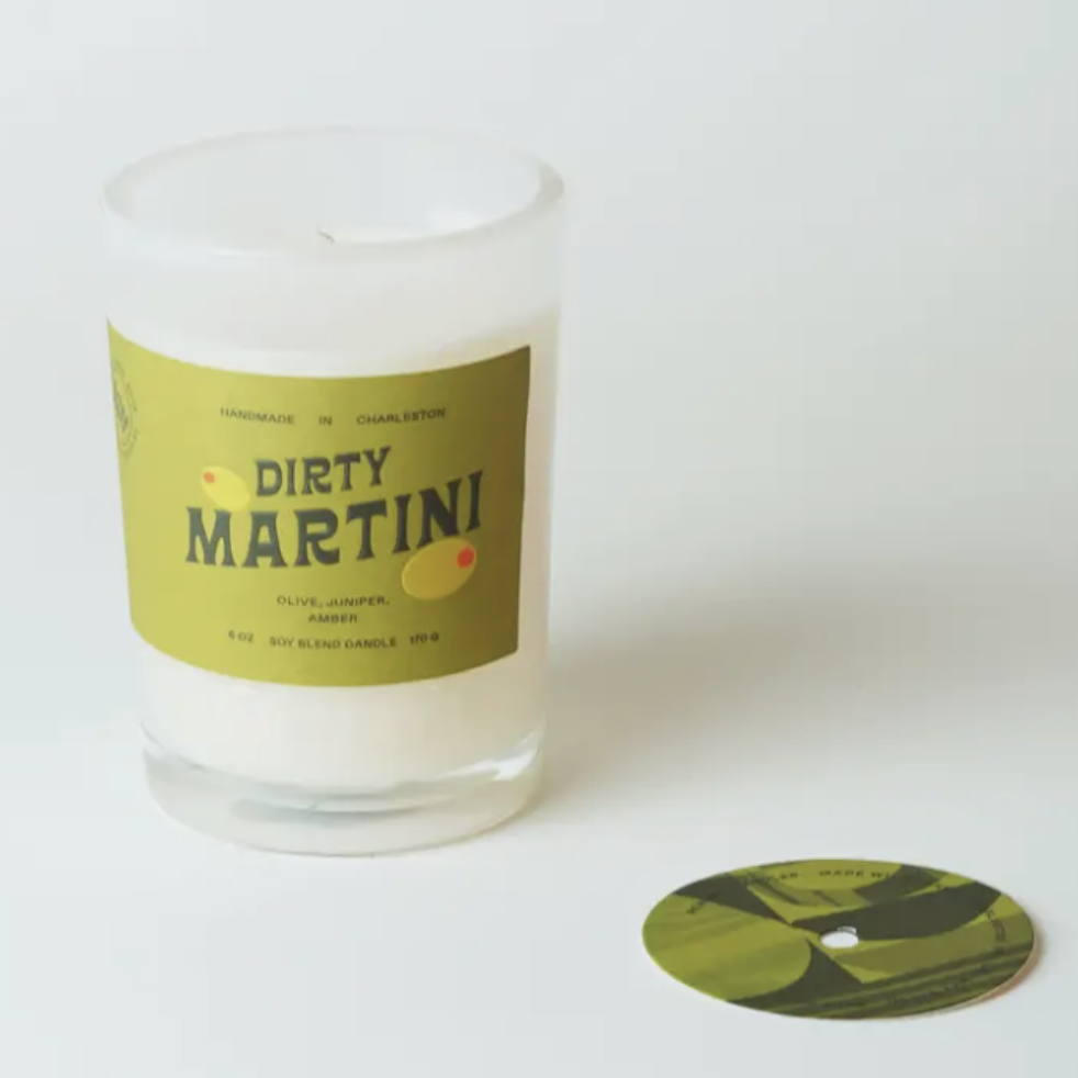 Candle labeled 'Dirty Martini' with a green label on a white background
