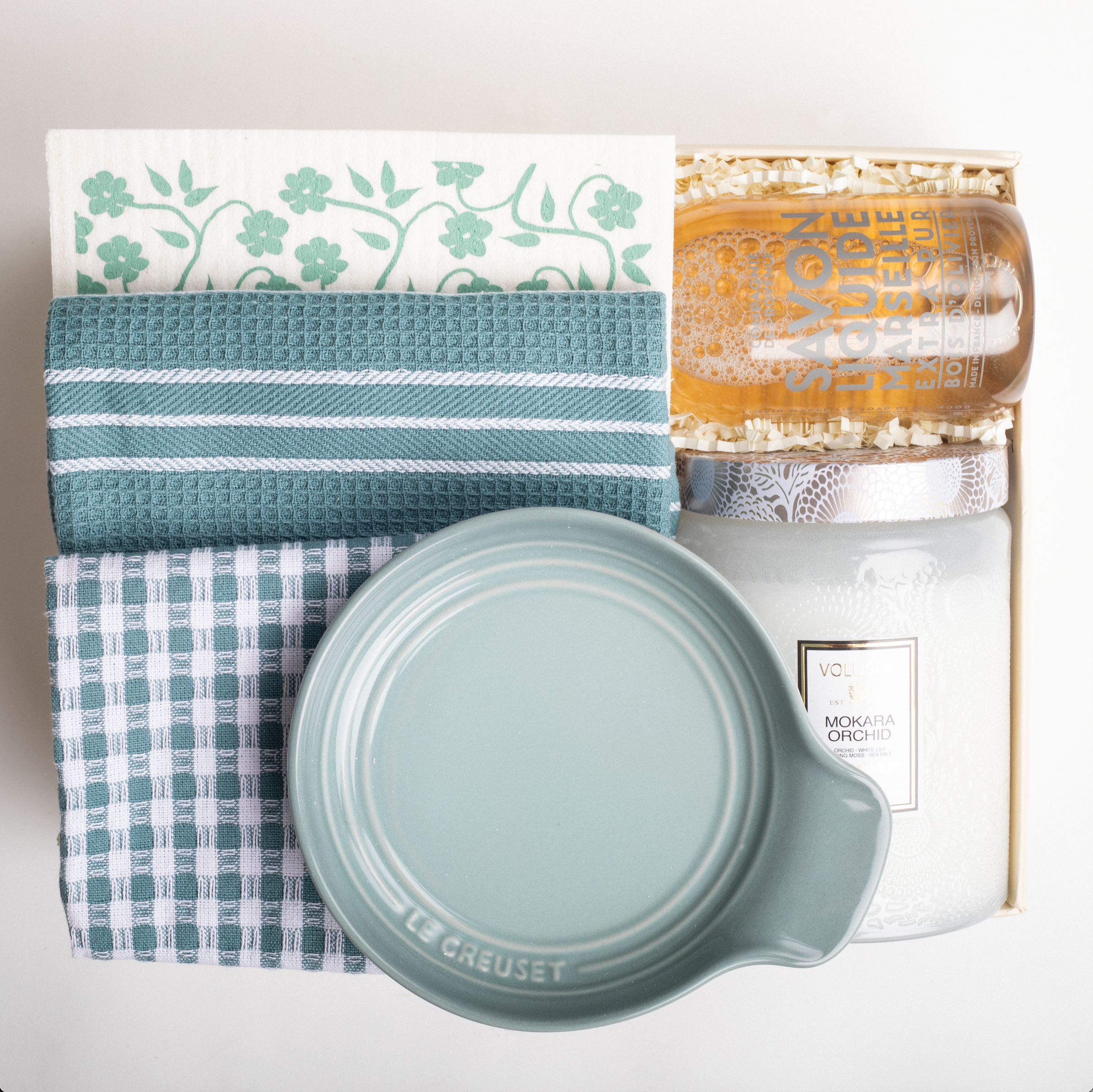 Collection of kitchen items including a jar, lid, and towels on a white background