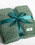 Green towel with a teal ribbon and 'VIVIE' label on a white background