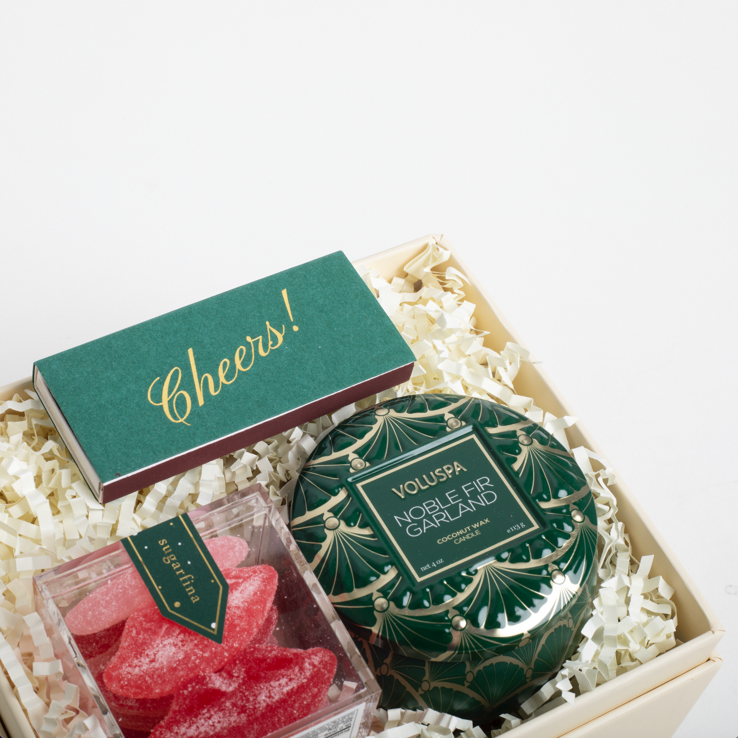 Decorative candle and candy set in a gift box with 'Cheers!' card on a white background