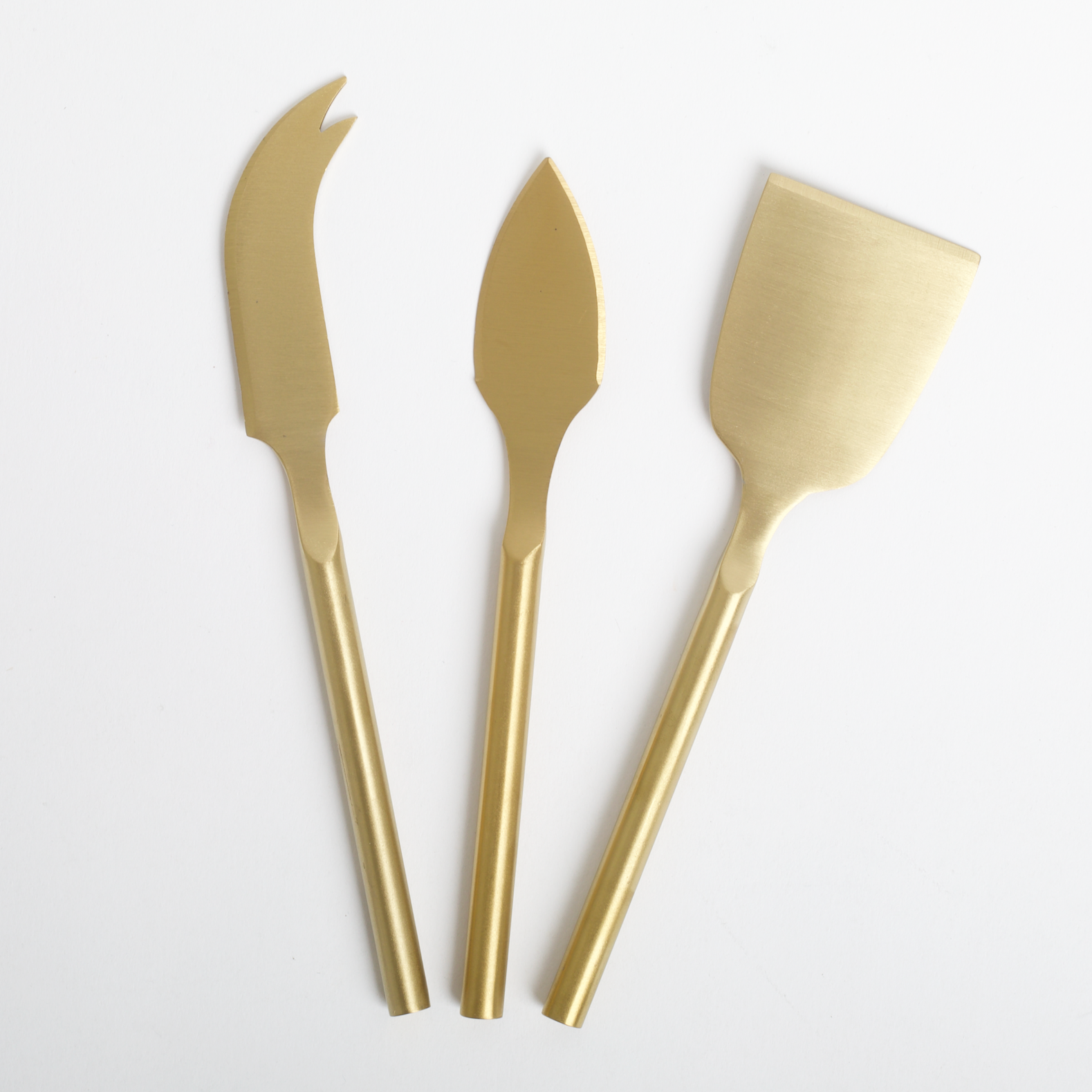 Three gold butter knives on a white background