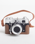 Vintage camera with a brown strap on a white background