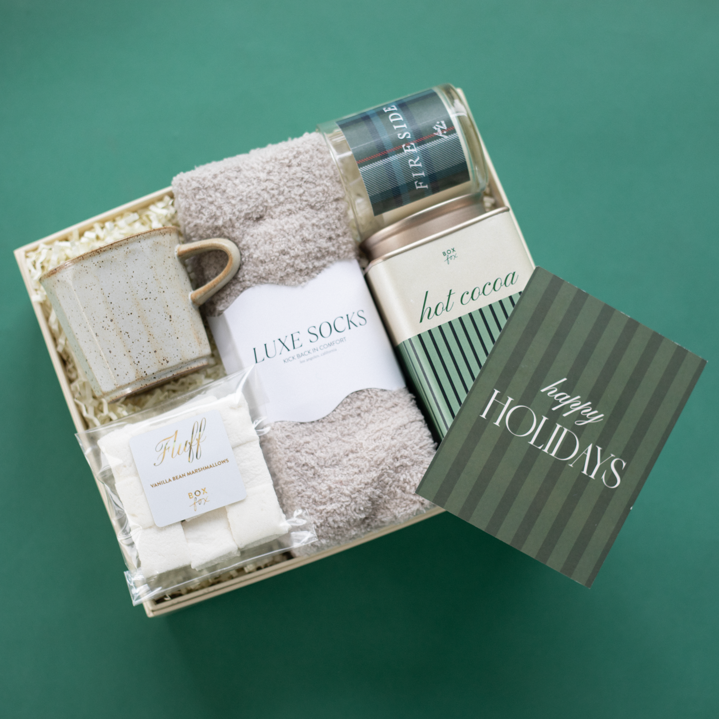 Gift set with socks, a mug, and a card on a green background
