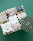 Gift set with socks, a mug, and a card on a green background