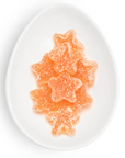 Star-shaped orange gummy candies on a white plate