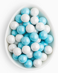 White and blue round candies in a white bowl on a white background