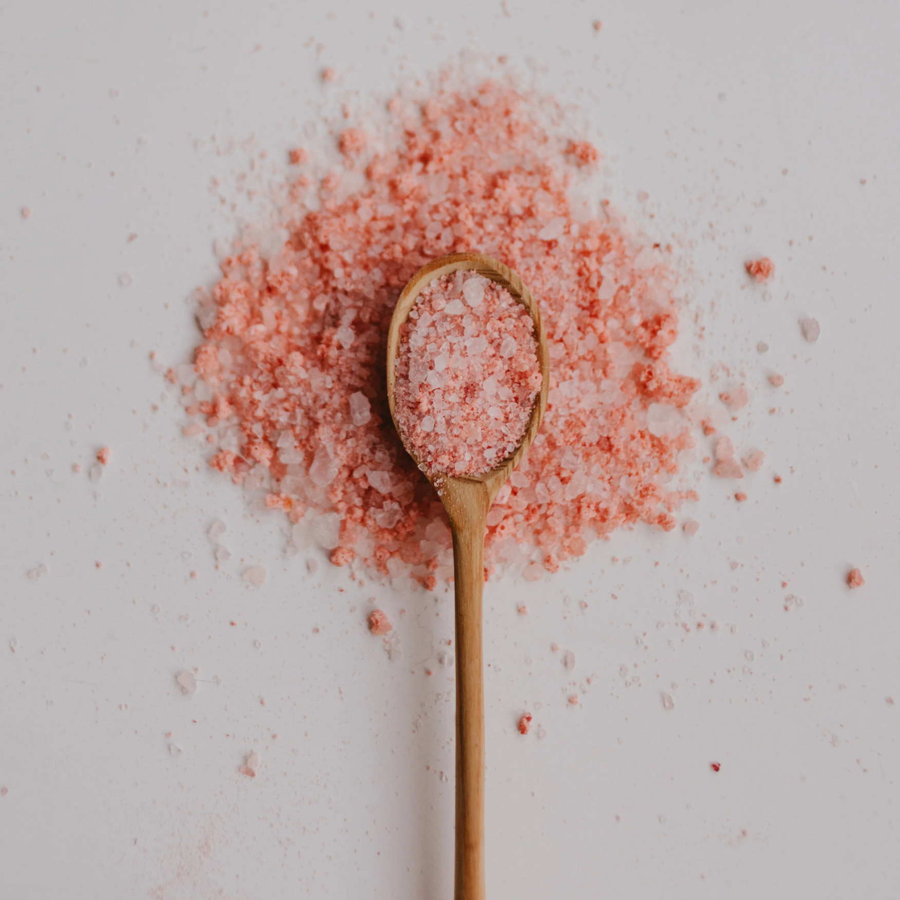 Spoon with pink Himalayan salt on a light background