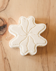 Flower-shaped bath bomb on a wooden surface