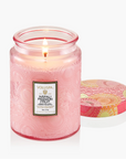 Pink candle with a Voluspa label on a white background