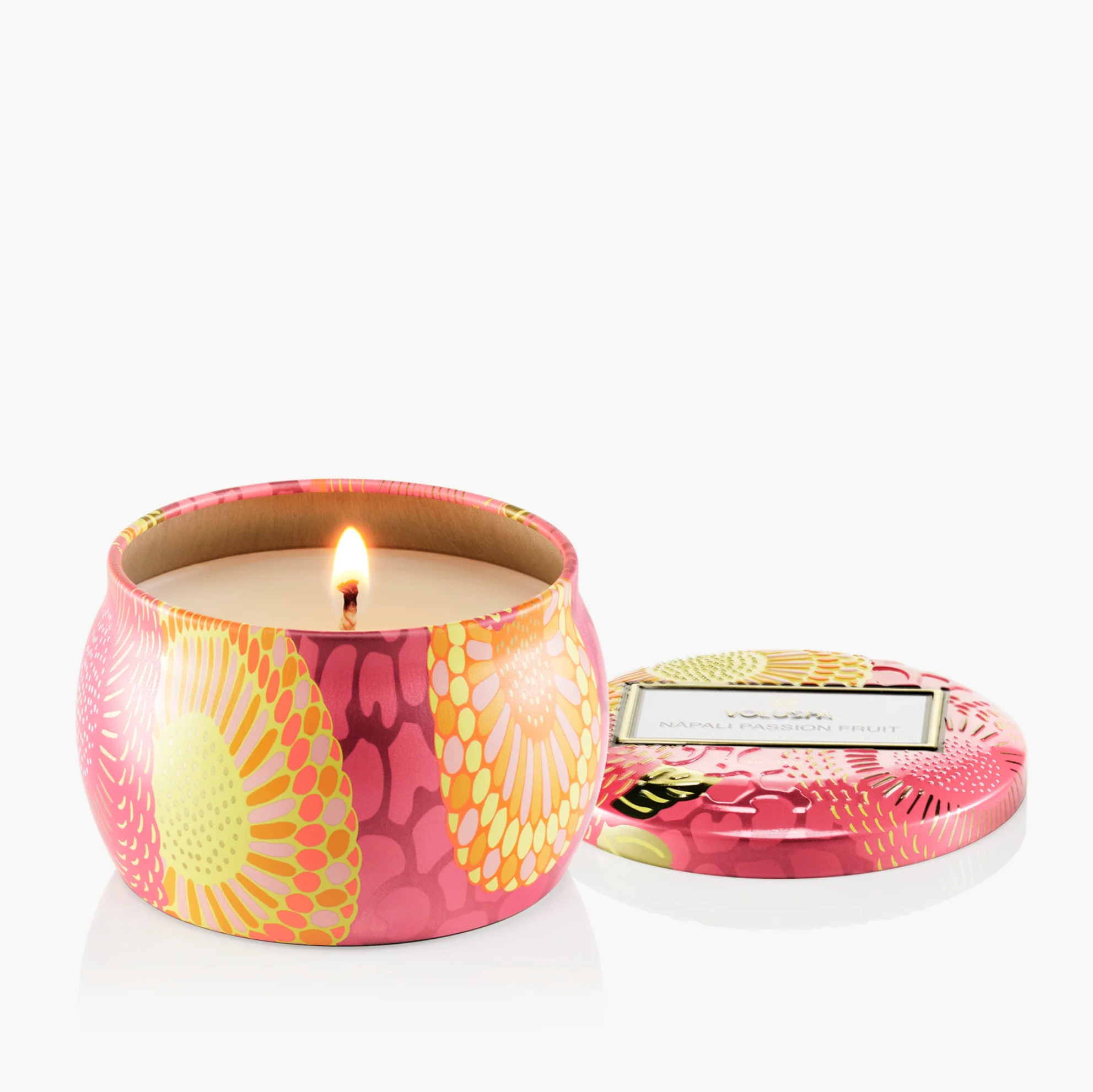 Candle in a colorful tin with a floral design on a white background