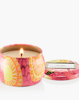 Candle in a colorful tin with a floral design on a white background