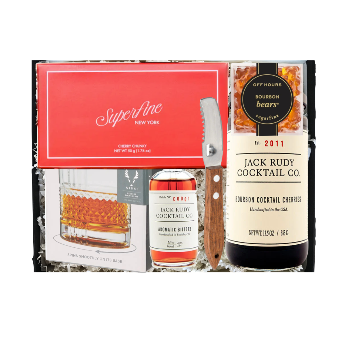 Cocktail kit with glasses, bottle, and cherries on a white background