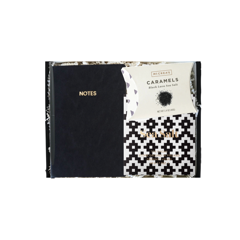 Black notebook with 'NOTES' text and a white caramels packaging with black and white pattern on a white background