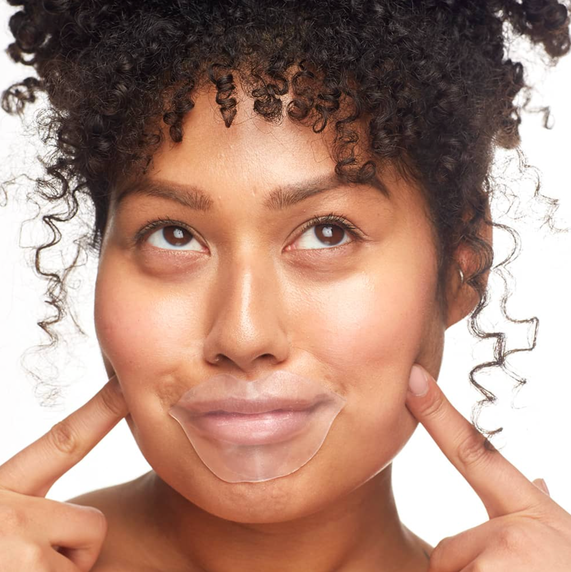 Woman pointing to her face with a clear sheet over it on a white background