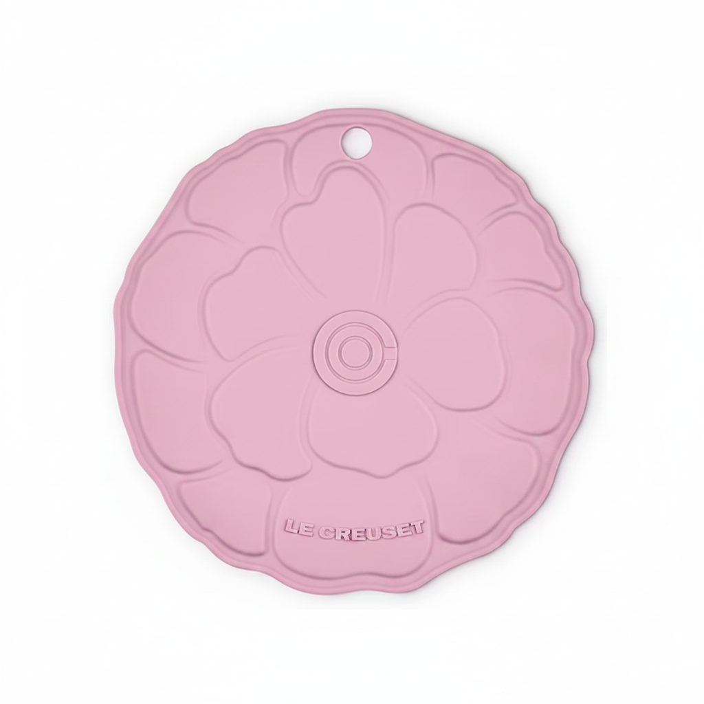 Pink trivet with floral design on a white background