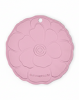 Pink trivet with floral design on a white background