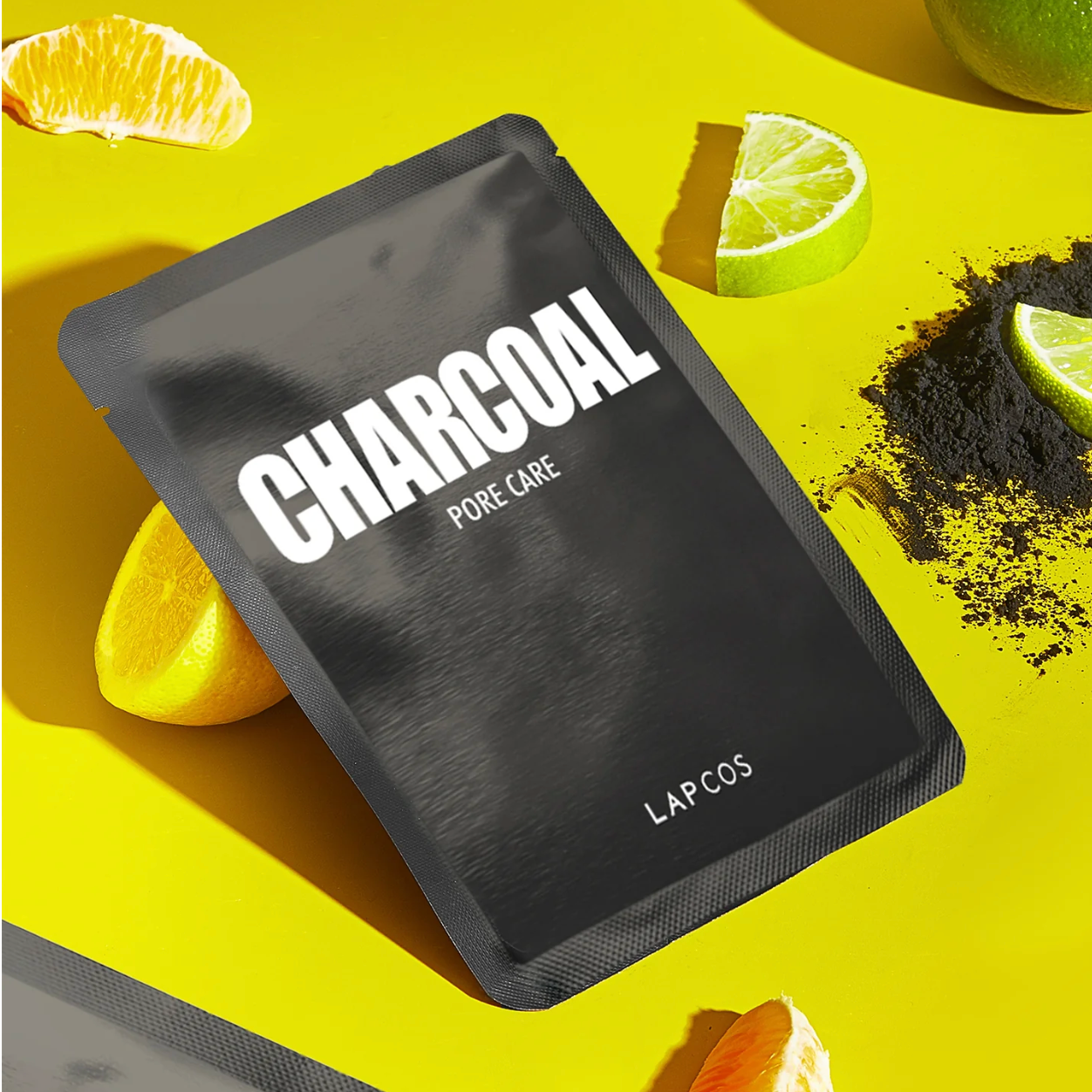 Black charcoal mask packaging with 'LAPCOS' branding on a yellow background with citrus fruits.