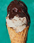 Ice cream cone with chocolate sauce on a teal background