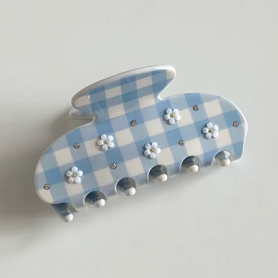 Decorative wall hook with blue and white checkered pattern and floral designs on a light gray background