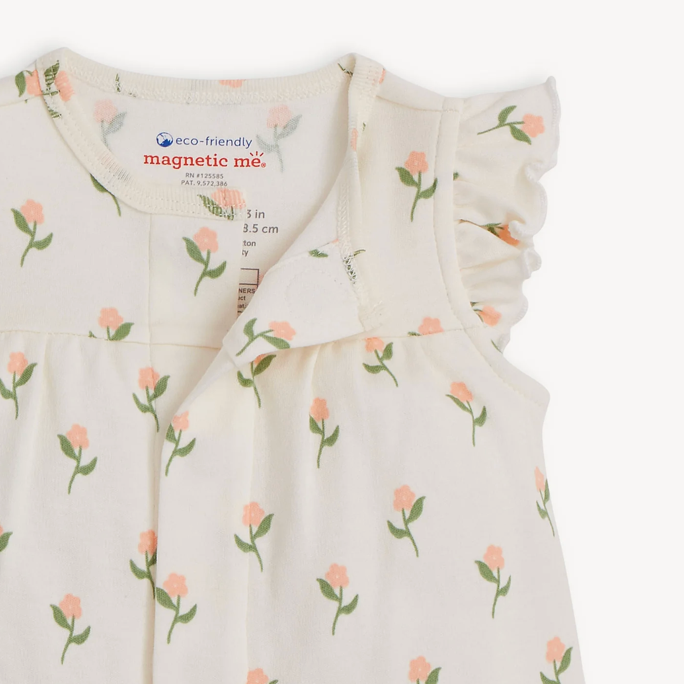 Baby dress with floral pattern and 'magnetic me' branding on a white background