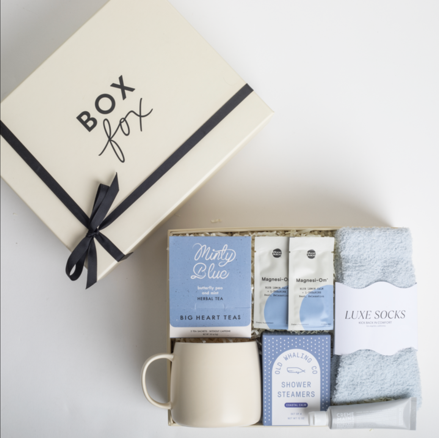 Gift set with tea, socks, and other items from Box Fox on a light background