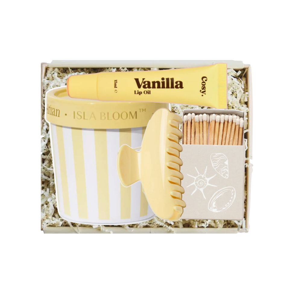 Set of beauty items including a lip balm, scrub brush, and matches in a gift box labeled 'Vanilla'.