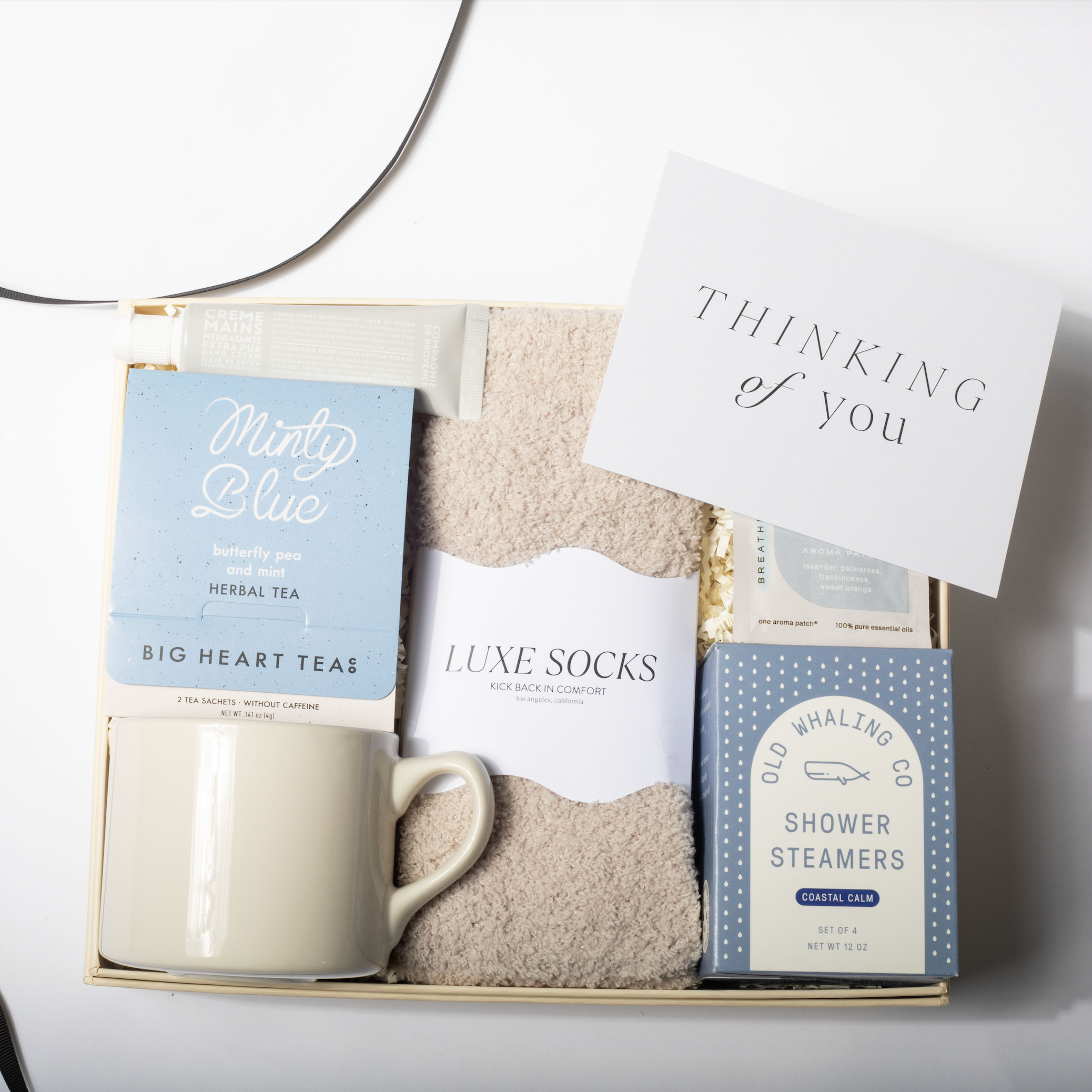 Gift set with mug, tea, socks, and card on a white background