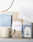 Gift set with mug, tea, socks, and card on a white background