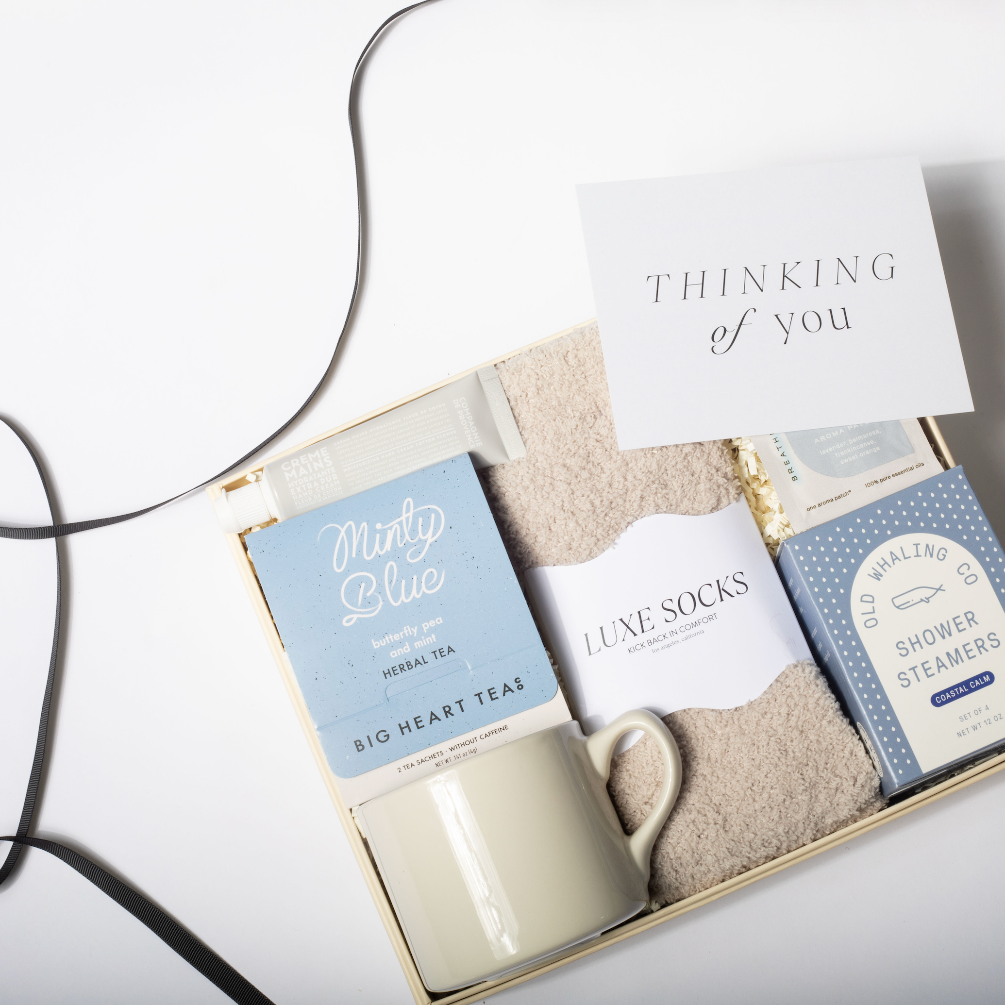 Gift set with mug, soap, and card labeled 'Thinking of You' on a white background