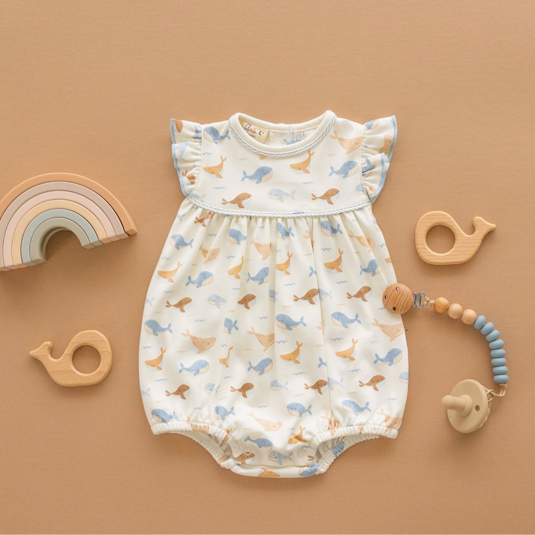 whale tales romper on an orange background