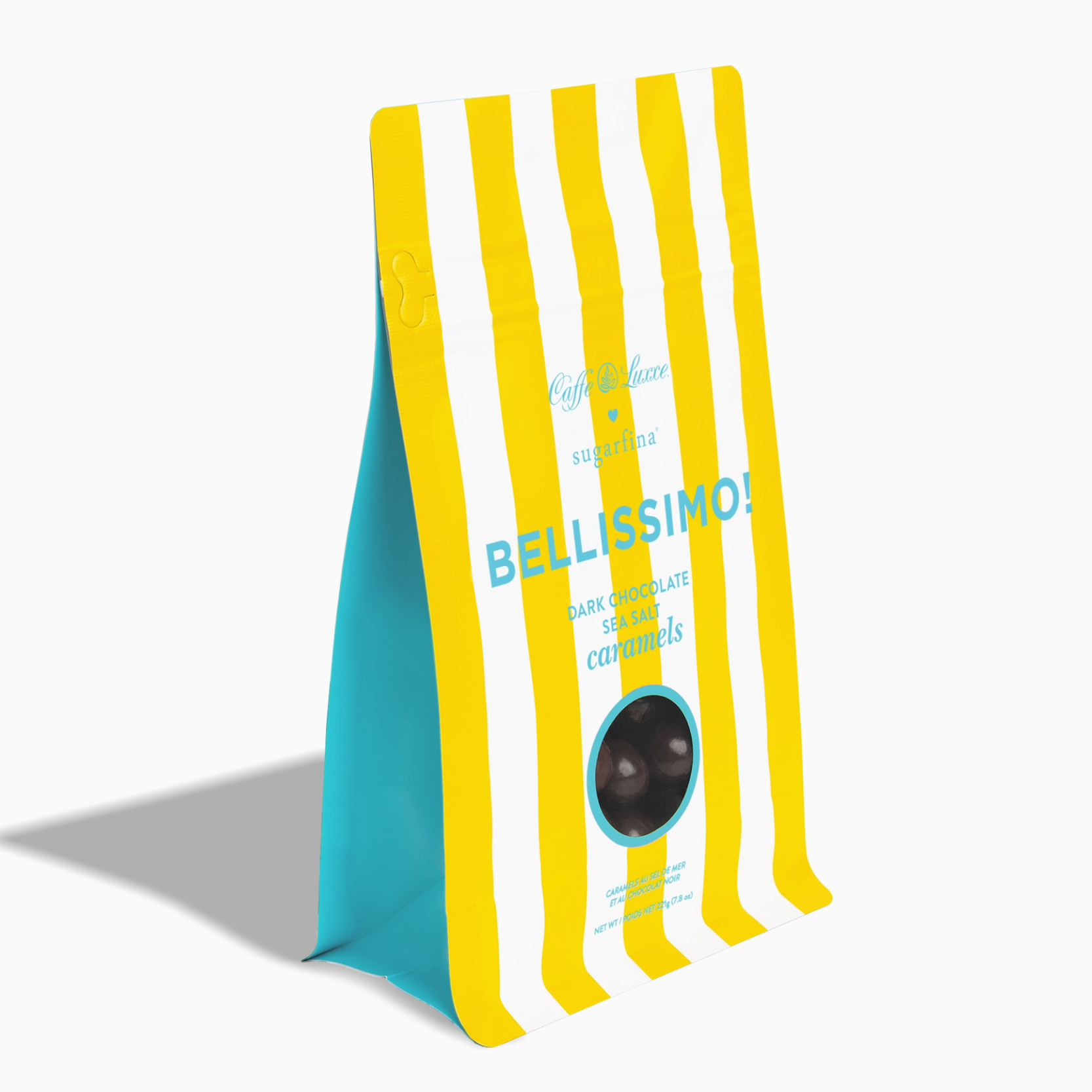 A standing pouch of Bellissimo dark chocolate caramels with yellow and white vertical stripes, a turquoise blue side panel, and a circular clear window showing dark brown chocolates inside, set against a plain white background.