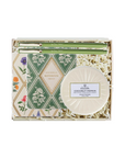 A boxed gift set from Volupta featuring a round coconut papaya soap, a patterned notebook, and green pens arranged in white crinkle paper filler inside a clear gift box.