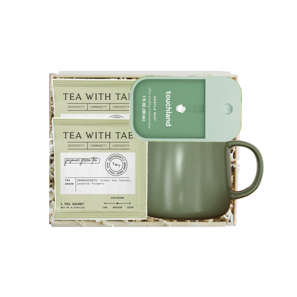 An olive green ceramic mug with a matching green lid sits in a white gift box with shredded paper, next to a printed tea sachet labeled 'TEA WITH TAIWAN' and a green card reading 'touchland'.