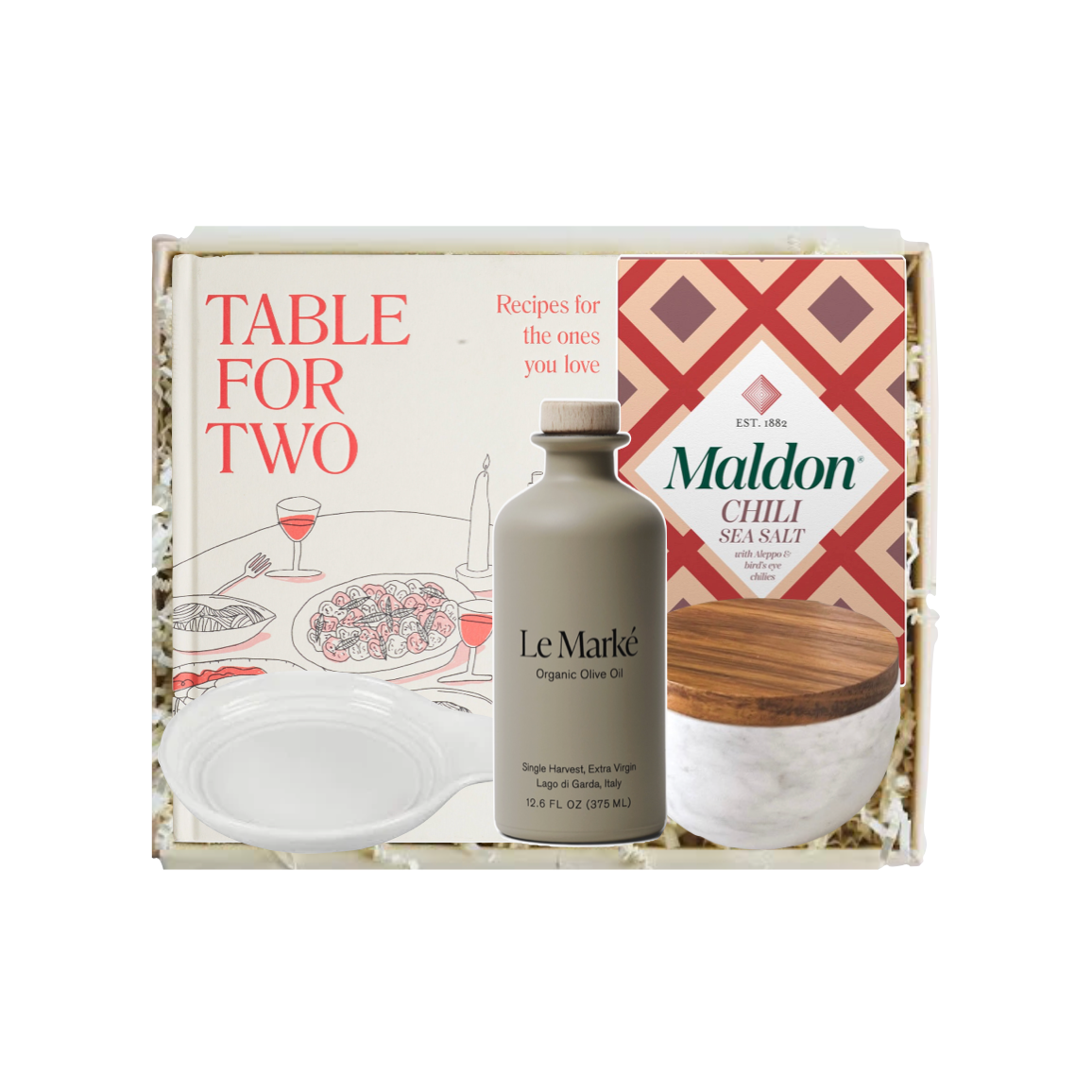 A gift set in a white box labeled 'TABLE FOR TWO' featuring a bottle of Le Marké Organic Olive Oil, a jar of Maldon Chili Sea Salt, and a printed recipe card, arranged with white filler.