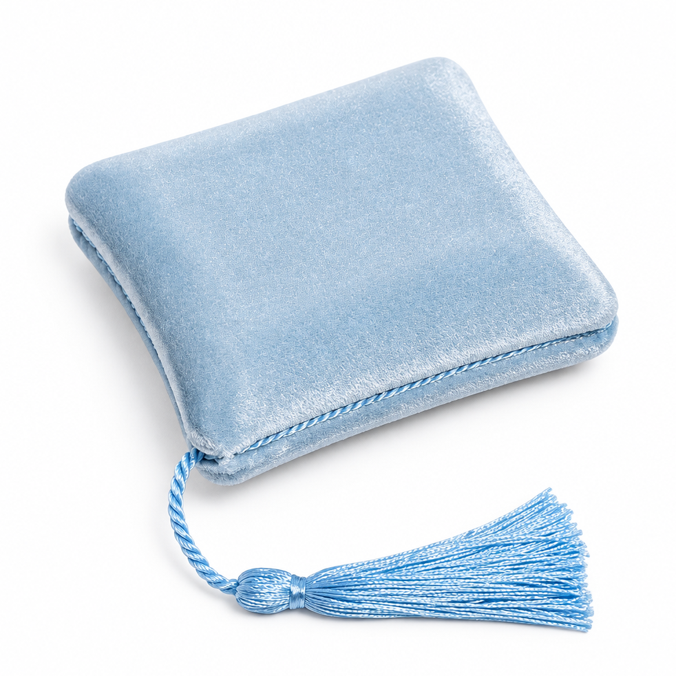 A light blue velvet square cushion with a matching blue tassel, shown on a white background.