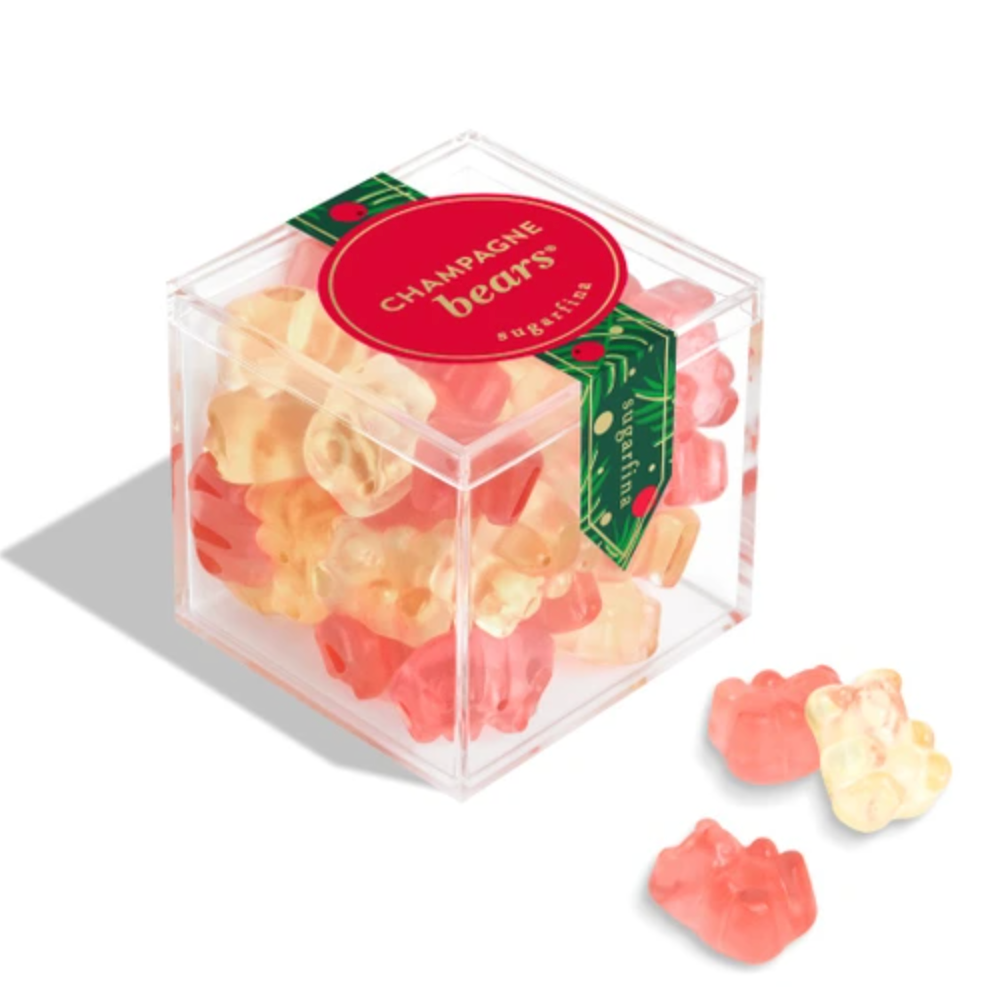 A clear cube-shaped container filled with colorful gummy bears, with a red round label reading 'CHAMOMILE BEARS' and a few gummy bears placed outside the container on a white background.