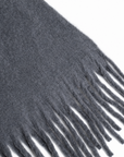 A close-up of a dark gray fuzzy scarf with fringe along one edge, featuring the name 'Tiffany' embroidered in red script on the side.