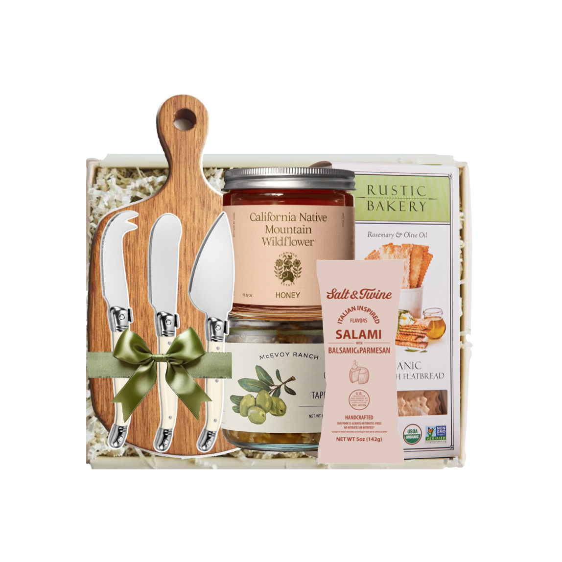 A gourmet gift basket set containing a wooden cutting board with three knives, a jar of California Native Mountain Wild Turkey Honey, a jar of Rustic Bakeri Rosemary and Olive Oil, a pack of Rustic Ranch Salami, and a pack of Rustic Ranch Anch & Hickory Bread, all arranged in a white gift box with a green ribbon.