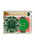 A boxed gift set containing a round green and gold patterned Voluspa Noble Fir Garland, a pack of pink Twisted Kisses sugarfins, and wooden matchsticks with green tips, all arranged in a white gift box with shredded paper.