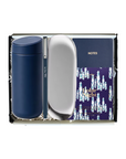 A Johnnie Walker gift set containing a navy blue tumbler, a silver oval mirror, and a blue and white patterned Johnnie Walker notes notebook inside a black gift box.