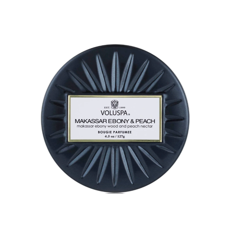 A round dark navy blue tin of Voluspa Maxissim Esbery &amp; Peach Extrait Parfum, shown from a top-down view on a solid white background.